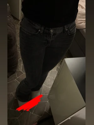 Jenas - Säljer ett par mörkgrå jeans med rak passform och klassisk femficksdesign. Defekt längst ner, se bild 3