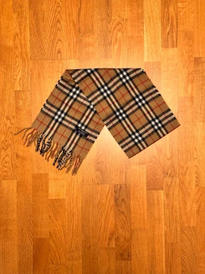 Beige Burberry halsduk - Säljer en beige halsduk från Buberry. Halsduken är gjord i 100% lamull och är i fint skick. Var inte rädd för några frågor. Pris diskuteras inte!