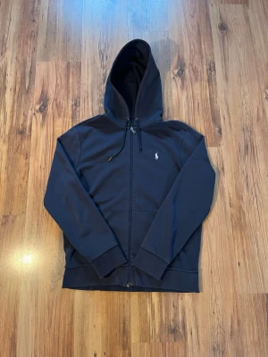 Mörkblå zip hoodie från Polo Ralph Lauren - Mörkblå Ralph lauren zip hoodie size M/175 i fint skick 8/10 skulle jag säga ✌️ finns något märke någonstans men är inget som syns. Längden mäter 65 cm, bredden 48 cm 📏  pris går att diskutera 🙈