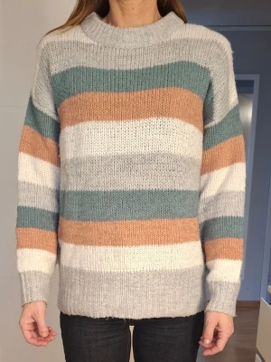 Randig stickad tröja i pastellfärger - Mysig stickad tröja med breda ränder. Tröjan har rund halsringning, långa ärmar och ribbstickade muddar vid ärmslut och nederkant.