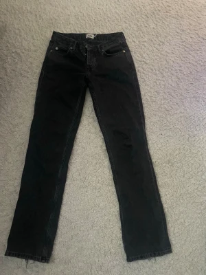 Svarta straight jeans från 157 - Snygga svarta jeans från 157 med klassisk femficksmodell och raka ben. Jeansen har en enkel design utan slitningar eller dekorationer, vilket gör dem lätta att matcha med olika stilar. Tillverkade i ett mjukt och bekvämt bomullsmaterial.