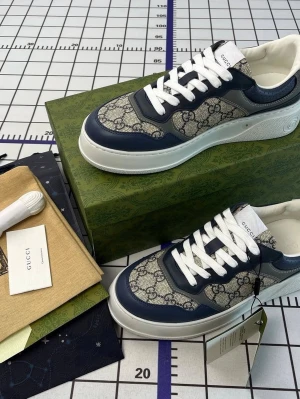 Gucci sneakers med blå detaljer finns i alla storlekar  - Snygga sneakers från Gucci med marinblå detaljer och klassiskt GG-mönster i beige och blått. Skorna har vita snören, rund tå och tjock vit sula. Tillverkade i en mix av skinn och textil för en exklusiv känsla. Perfekta för dig som vill sticka ut med stil.