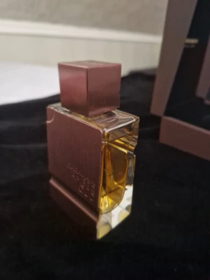 Al Haramain Amber Oud Tobacco Edition - Amber Oud Tobacco Edition från Al Haramain är en lyxig parfym i en fyrkantig, guldbrun flaska med metallisk finish och tydlig märkning. Flaskan har en robust, modern design och innehåller en gyllene vätska som ger exklusiv känsla.