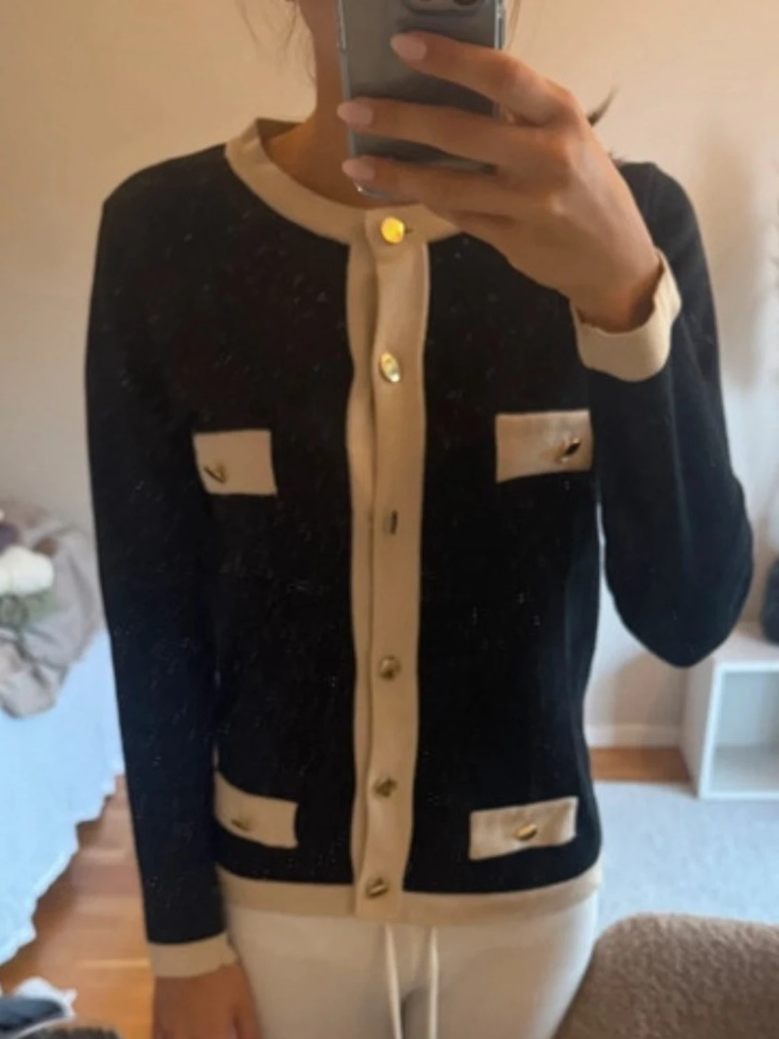 Svart kofta med krämvita detaljer