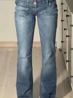 Blå bootcut jeans med låg midja - Snygga blå bootcut jeans med låg midja innerbenslängd är 85cm o midjan är 37cm
