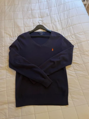 Mörkblå v-ringad tröja Polo Ralph Lauren - Mörkblå v-ringad tröja från Polo Ralph Lauren i storlek S😮‍💨Tröjan har ett riktigt skönt material och är självklart äkta!👑Bara att höra av dig vid andra funderingar👌