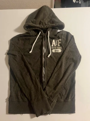 Abercrombie & fitch zip hoodie mörkgrön - Abercrombie & fitch zip hoodie i mörkgrön färg riktigt snygg och väldigt eftertraktad. Väldigt bra skick inga fel storlek M passar 170-180 cm lång pris endast 458 kr kolla även mina andra artiklar för mer och rabatt 😃