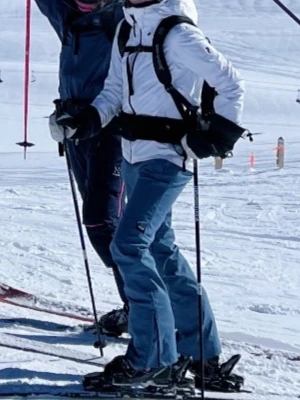 Blå skidbyxor dope - Säljer ett par blå täckbyxor perfekta för skidåkning. Byxorna har raka ben med dragkedja vid benslut för enkel påtagning över pjäxor. De är tillverkade i ett slitstarkt syntetmaterial och har en klassisk passform.