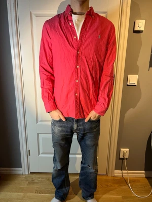 Ralph Lauren skjorta - Säljer en Ralph lauren skjorta i en cool nyans av rosa i mycket fint skick! Modellen på bilden är 183 och väger 65kg. Vid fler frågor hör av er!
