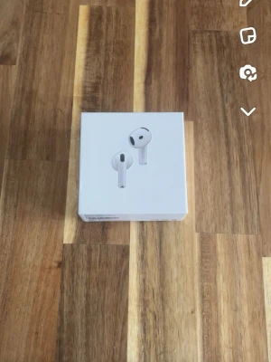 Apple AirPods trådlösa hörlurar - Säljer ett par vita Apple AirPods 4 med laddningsetui. Snygg och stilren design i plast, perfekt för dig som vill ha trådlösa hörlurar med bra ljud och enkel anslutning till iPhone eller andra Apple-enheter. Allt originaltillbehör och förpackning medföljer.
