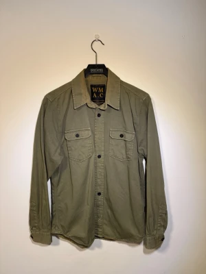 Wrenchmonkees overshirt - En militärgrön denim overshirt från Wrenchmonkees. Plagget är i fint skick utan skador. Skriv pm för frågor och förslag på pris.