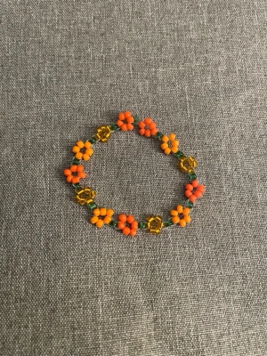  blommigt pärlarmband storlek S  - handgjort armband med pärlor i orange. 