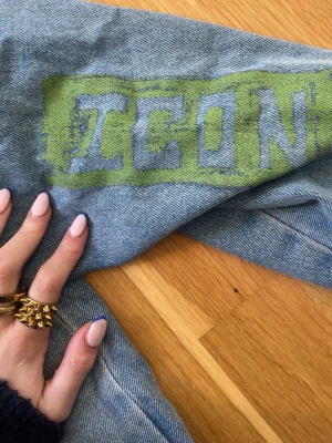 Ljusblå jeansjacka med tryck - Unik ljusblå jeansjacka med coola tryck på ryggen och ärmen. Den är Värkligen skit cool med massor av slitz och färger. Den är i storlek M men de passar mig relativt bra som har xs. ❤️❤️