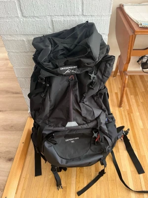 Svart ryggsäck Swedemount Expedition 70L - Stor svart ryggsäck från Swedemount, modell Expedition 70L. Ryggsäcken har flera fack, justerbara remmar och smarta detaljer som dragsko upptill. Perfekt för längre äventyr och resor där du behöver mycket packutrymme. Väskan är endast testanvänd en gång och är alltså i ett mycket bra skick, pris är diskuterbart.