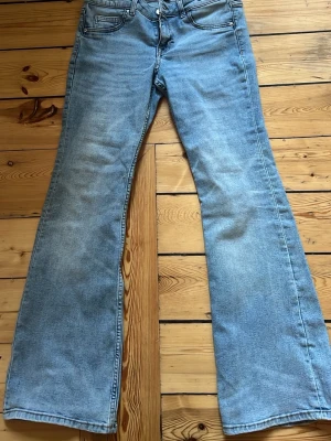 Ljusblå bootcut jeans - Snygga ljusblå jeans med bootcut-modell och klassisk femficksdesign. Jeansen har normalhög midja och är tillverkade i ett mjukt denimtyg. Perfekta för dig som gillar en retroinspirerad look.