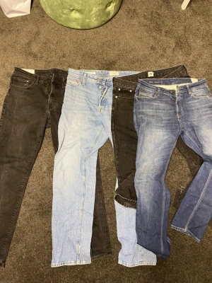 Fyra par jeans från H&M, Jack and Jones  - Säljer fyra par jeans från H&M i olika tvättar: svart, ljusblå, mörkblå och gråsvart. Alla är Regular fit med klassisk femficksdesign och dragkedja eller knappgylf. Perfekta för dig som gillar en avslappnad men snygg stil.