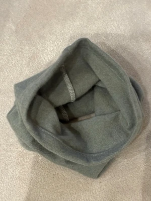 Grön tubhalsduk i 100% kashmir  - En enkel och stilren grön tubhalsduk i mjukt och kashmir material. Perfekt att dra över huvudet för extra värme under kyliga dagar. Halsduken är enfärgad och har en slät yta utan mönster. 100%% kashmir