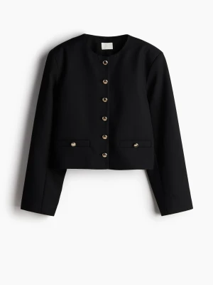 Svart kavaj med guldknappar - Stilren svart kavaj med rund halsringning och raka axlar. Kavajen har dekorativa guldknappar framtill och vid fickorna, samt två fickdetaljer. Kortare modell som ger en modern look. Perfekt för att lyfta vilken outfit som helst.