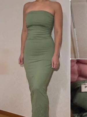 Grön axelbandslös långklänning från Pull & Bear - Säljer en snygg grön axelbandslös långklänning från Pull&Bear. Klänningen har en figurnära passform och är tillverkad i ett mjukt material som sitter bekvämt mot kroppen. Perfekt för dig som vill ha en stilren och trendig look.