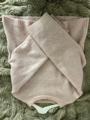 Ljusrosa stickad tröja Gina Tricot - Mysig ljusrosa stickad tröja från Gina Tricot med rund halsringning och ribbade muddar vid ärmslut och nederkant. Tröjan har en enkel, klassisk design och är tillverkad i ett mjukt material som passar perfekt för kyligare dagar.