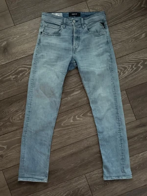  Replay Grover  - Säljer ett par ljusblå replay Grover med klassisk femficksdesign och knappgylf. Jeansen har en snygg tvättad look och raka ben. Materialet är mjukt denim som ger en skön känsla och passar perfekt till en avslappnad stil. Där är en liten reva där bak i knävecket, därav priset. Annars bra skick