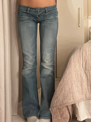 Blå bootcut jeans med låg midja - Snygga blå bootcut jeans med låg midja de går att vända åt två håll ett ljusare och ett mörkare. Bild finns på båda skriv för fler bilder❤️ midjemått 39 cm rakt över och innerbenslängden är 84cm❤️