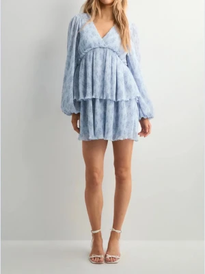 Ljusblå kort omlottklänning - Säljer min klänning jag köpte som jag skulle ha på skolavslutning, men kom aldrig till användning. Det är super skön och passar perfekt till sommaren. Köpte för 600kr