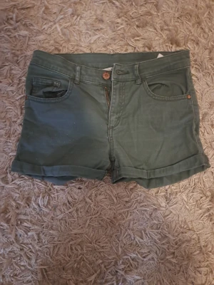 Gröna shorts  - Snygga gröna shorts med klassisk femficksdesign. Perfekta för varma dagar och enkla att matcha med olika stilar. Storlek 158. Pris kan diskuteras