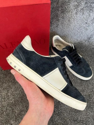 Valentino flycrew  - Säljer dessa riktigt schyssta och eftertraktade Valentino Flycrews i storlek 43. Skorna är i den eftertraktade mörkblå färgen och skicket är fint som du ser på bilderna. 2 nitar saknas men går enkelt att köpa till på plick. Hör av dig vid fler frågor eller funderingar//