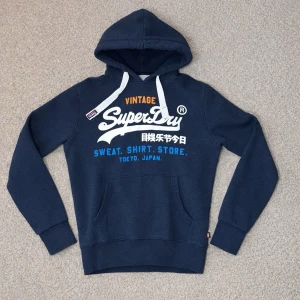 Superdry Hoodie - Tja! Säljer en Superdry Hoodie i storleken (M)-fast den sitter som (S/M)-skick 8/10. Vid minsta fundering hör av er!