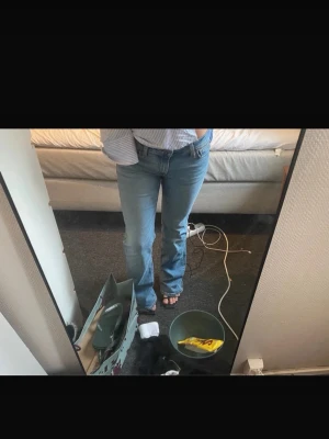 Ljusblå raka jeans från Levi's - Säljer ett par klassiska ljusblå jeans från Levi's med rak passform och normal midja. Jeansen har fem fickor, Levi's ikoniska röda lapp på bakfickan och patch i läder bak i midjan. Perfekta till en avslappnad stil och tillverkade i slitstark denim.
