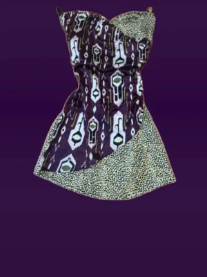 Kort leopardmönstrad klänning - Unik kort klänning med leopardmönster och coolt grafiskt mönster framtill. Klänningen är axelbandslös och har dragkedja baktill för enkel påklädning. Perfekt för dig som vill sticka ut med en mix av mönster och färger. Storlek 8(s)  tar emot prisförslag 