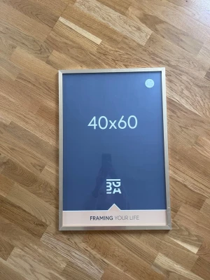Guldfärgad fotoram 40x60 från BGA - Snygg fotoram från BGA i storleken 40x60 cm med guldfärgad metallram. Perfekt för posters, foton eller konstverk. Modern och stilren design som passar i de flesta rum. Ramen har glasfront och är enkel att öppna för att byta motiv. Säljs oöppnad då jag beställde fel storlek.