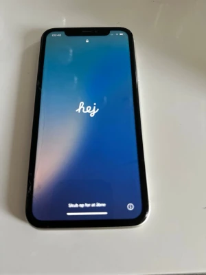Vit iPhone 11 - Säljer en vit iPhone 11 med stilren design och rundade kanter. Telefonen har en stor skärm med tunn ram och Face ID. Baksidan är i glas och har två kameror samt Apple-loggan i mitten. Perfekt för dig som gillar snygg och modern teknik. Funkar felfrit säljer den då den inte kommer till användning längre.