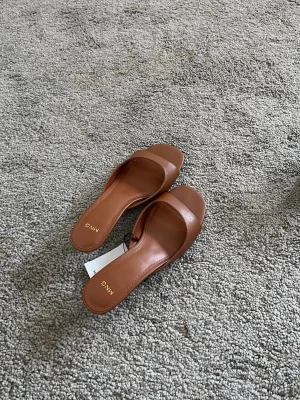 Bruna sandaler med låg klack från Mango - Snygga bruna sandaler från Mango med öppen tå och låg klack. Strl 38. Aldrig använda. 