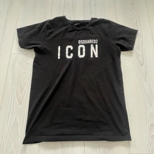 Svart DSQUARED2 ICON t-shirt - Svart t-shirt från DSQUARED2 med stor vit 'ICON'-text på bröstet och DSQUARED2-logga ovanför. Storlek XS! 