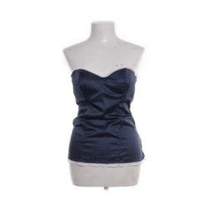 Mörkblå prickig tubtopp från Intimissimi - Säljer en mörkblå tubtopp från Intimissimi med små vita prickar och spetsdetaljer upptill och nedtill. Toppen är bandeau. Köpte på plick men passade tyvärr inte. I superfint skick ❤️