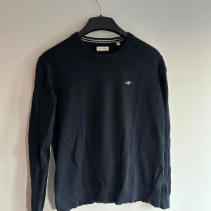 Mörkblå Gant tröja 164/Xs - En Mörkblå Gant tröja som jag fick i födelsedagspresent för cirka 1 år sedan den blev för liten nu. Tröjan är i 158-164/Xs