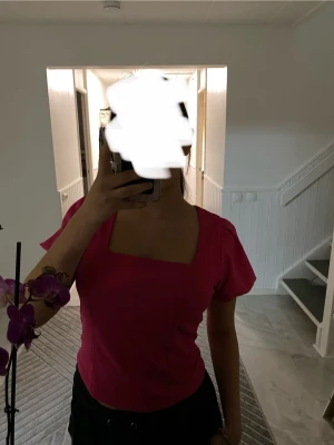 Rosa blus med fyrkantig hals - Säljer en snygg rosa blus med fyrkantig halsringning och puffiga korta ärmar. Toppen har en figurnära passform och är tillverkad i ett lätt, vävt material som ger en fräsch känsla. Perfekt för dig som vill ha en färgstark och trendig topp. OBS säljer exakt likadan i vitt om någon är intresserad.