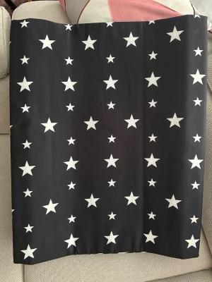 Svart väst med vita stjärnor från Beemoo - Cool svart väst från Beemoo med vita stjärnor över hela ytan. Västen har en rak form och är tillverkad i polyester med mjuk polyuretanfyllning. Perfekt för dig som gillar att sticka ut med ett stjärnmönster.