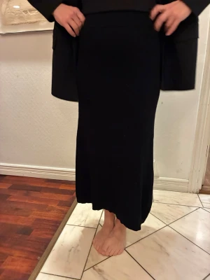 Svart långkjol från & Other Stories - Säljer en svart långkjol från & Other Stories, Los Angeles Atelier. Kjolen har en enkel och stilren design med rak passform och resår i midjan. Perfekt att matcha med en snygg topp eller stickad tröja. Materialet känns mjukt och bekvämt mot huden.