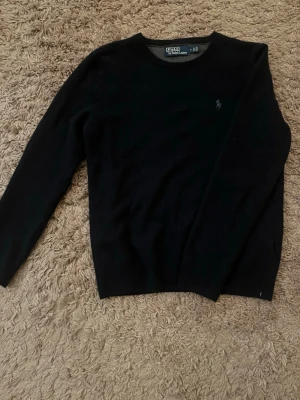 Svart stickad tröja från Polo Ralph Lauren - Riktigt fet Ralph lauren tröja, 100% i ull och är M men sitter som S. Notera att den har ett litet hål som knappt syns. Pris kan diskuteras. 