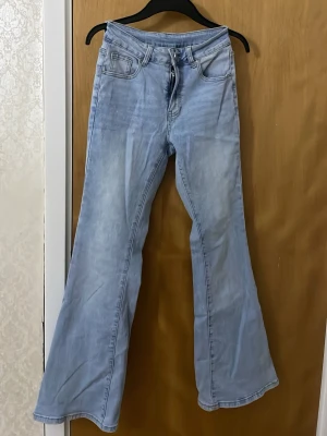Bootcut ljusblå jeans från SHEIN XS - Snygga ljusblå bootcut jeans från SHEIN i storlek XS. Jeansen har klassisk femficksdesign, dragkedja och knapp framtill samt bälteshällor. Materialet är jeans med en mjuk känsla och passformen är loose med utsvängda ben.