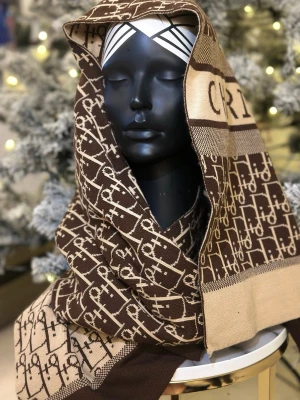 Beige och brun stickad väst från Dior - Säljer en snygg stickad väst från Dior i beige och brunt med ikoniskt logomönster och tydlig Christian Dior-text. Västen har en klassisk passform och är perfekt för lager-på-lager-stil. Materialet är mjukt och känns lyxigt mot huden.