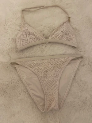 Bikini - spetsmönstrat bikini-set med triangelformad överdel och matchande underdel.