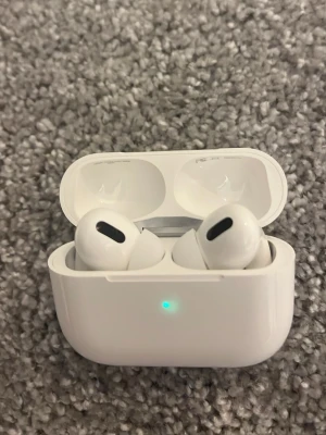 AirPods Pro (Minst 250kr) - Säljer ett par Apple AirPods Pro i mycket fint skick. Komplett med laddningsetui, aktiv brusreducering och transparensläge. Både hörlurar och etui är utan synliga repor eller skador. Fullt fungerande och visar 100% batteri på båda hörlurarna och etuiet.