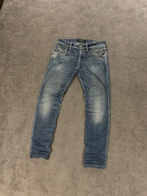 Replay Anbass  jeans blå - Säljer ett par Replay Anbass jeans i blå tvätt med snygga slitningar. Klassisk femficksmodell med Replay-logga vid fickan och detaljerade sömmar på bakfickorna. Jeansen är i nyskick och är bara använda ett fåtal gånger alltså inga skador✅ nypris:1300 mitt pris: 439kr🤩 det är bara att höra av dig om du har några funderingar och priset går självklart att diskutera✅👍W29 L30