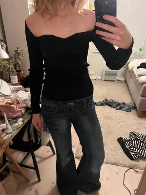 Svart offshoulder ribbad topp från MNG - Säljer en svart, ribbad offshoulder topp från MNG i storlek L. Toppen har långärmade ärmar och en snygg, hjärtformad halsringning som ger en elegant vibe.