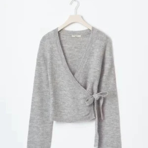 Grå omlottkofta från Gina tricot  -  grå omlottkofta från Gina tricot med knyt i sidan och v-ringad hals. Bara använd 5 gånger