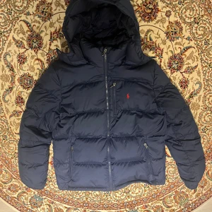 Ralph Lauren Puffer  - Tjena, säljer en fet Ralph lauren jacka i mörkblå färg som är i nyskick!! Den är i barnstorlek XL vilket är samma sak som S i vuxenstorlek. Priset är ej hugget i sten och hör av er vid frågor eller funderingar. 